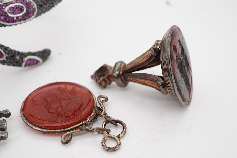 A collection of jewels including a snake bracelet, comprising: a hinged bangle modelled as a snake in silver, pavé-set with circular-cut black sapphires and synthetic rubies, its tongue a marquise-shaped synthetic ruby,